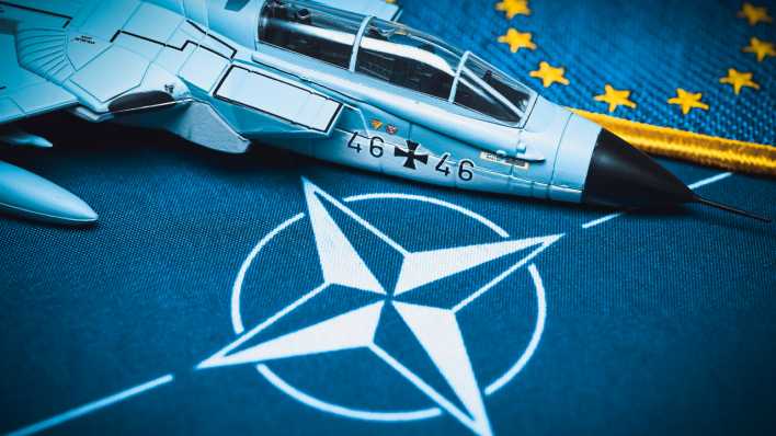 Militärjetmodell auf NATO-Fahne
