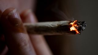 Eine Person raucht einen Joint (Bild: picture alliance/dpa/Fabian Sommer)