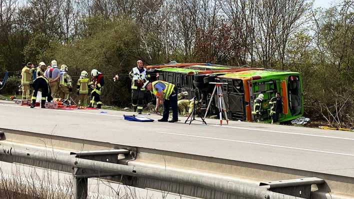 Ein Reisebus liegt zur Seite gekippt an der Unfallstelle auf der A9 bei Leipzig.