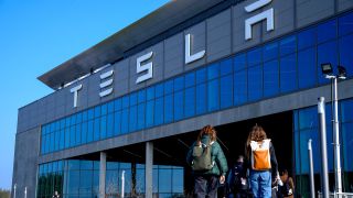 Menschen gehen ins Tesla-Werk Grünheide