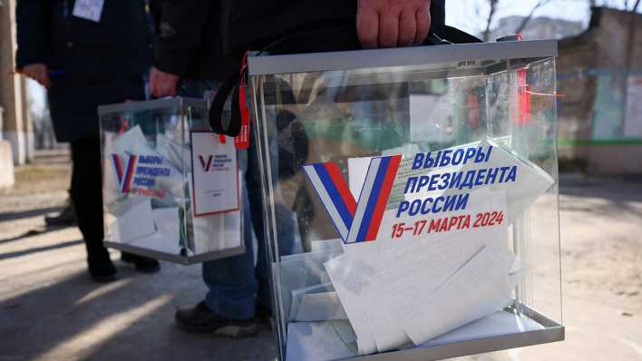 Wahlhelfer mit Wahlurnen in der von Russland besetzten Stadt Rubischne in der Ukraine.
