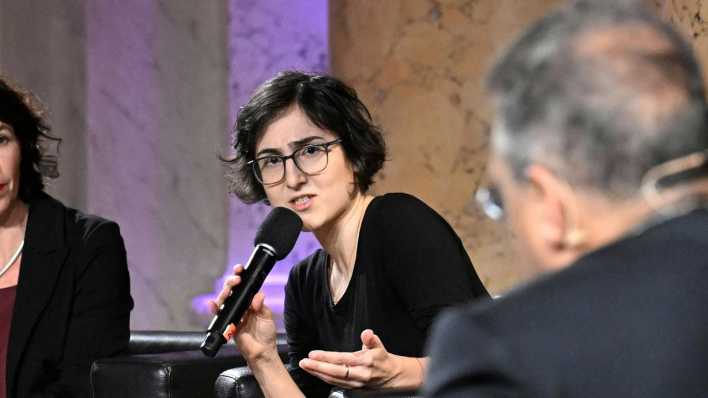 Die Autorin Solmaz Khorsand hält ein Mikrofon.