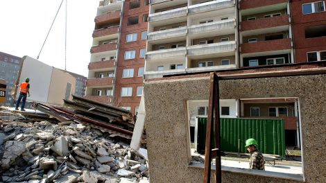 ARCHIV - Ein Bauarbeiter dirigiert am 18.03.2004 die demontierte Betonplatte eines elf-geschossigen Wohnhauses in Berlin-Marzahn auf einen Stapel zum Zerkleinern. (Bild: dpa)