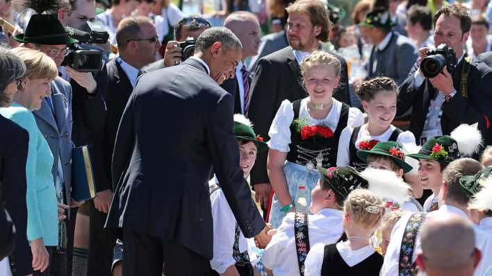 Bundeskanzlerin Angela Merkel (CDU, l) und US-Präsident Barack Obama unterhalten sich am 07.06.2015 in Krün (Bayern) mit Besuchern in Trachten. Foto: dpa