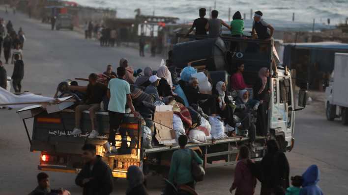 Geflüchtete Männer, Frauen und Kinder transportieren ihr Gepäck auf einem Truck durch Rafah (Bild: picture alliance/ZUMAPRESS.com/Omar Ashtawy)