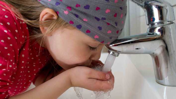 SYMBOLBILD: Das fünfjährige Mädchen Amy trinkt Leitungswasser aus einem Wasserhahn in der elterlichen Wohnung in Sieversdorf, aufgenommen am 20.03.2012. (Bild: Patrick Pleul/dpa)