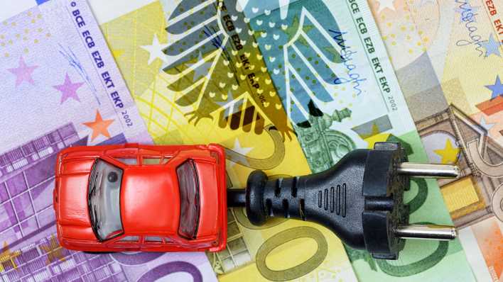 Miniaturauto mit Stecker auf Euroscheinen und Bundesadler, Kaufprämie für Elektroautos Miniaturauto mit Stecker auf Euroscheinen und Bundesadler, Kaufprämie für Elektroautos