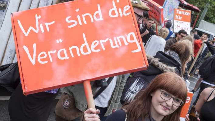 Immer mehr Menschen wollen aktiv Politik mitgestalten. Eine junge Frau zeigt auf einer Demo ein Schild mit der Aufschrift "Wir sind die Veränderung". Immer mehr Menschen wollen aktiv Politik mitgestalten. Eine junge Frau zeigt auf einer Demo ein Schild mit der Aufschrift "Wir sind die Veränderung".