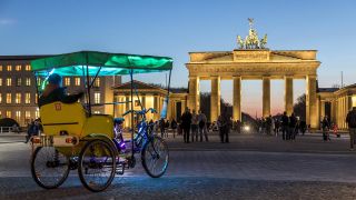 Eine Fahrradrikscha wartet vor dem Brandenburger Tor in Berlin auf Kundschaft (Bild: imago)