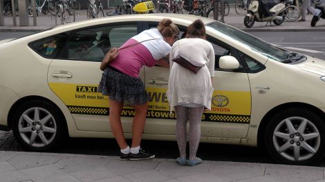 Touristinnen informieren sich bei einem Taxifahrer am Alexanderplatz