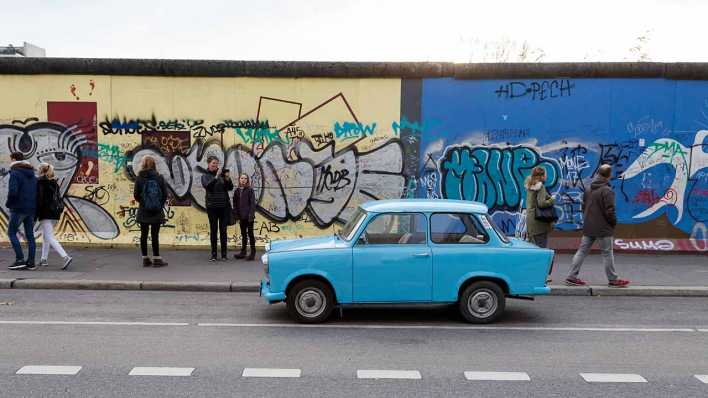 Trabant vor der Eastside-Gallery in Berlin (Bild: Stefan Zeitz/imago)