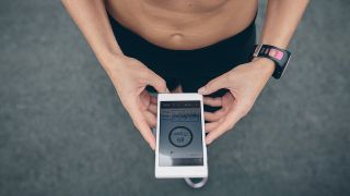 Sportler schaut auf seine Fitness-App