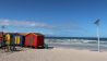 Ein Strand mit bunten Strandhäuschen in der Nähe von Kapstadt