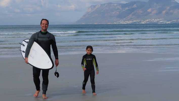 Die weiten Strände vor Kapstadt laden geradezu ein zum Surfen. Hier: Vater Jörg Poppendieck mit Tochter Thandi Die weiten Strände vor Kapstadt laden geradezu ein zum Surfen. Hier: Vater Jörg Poppendieck mit Tochter Thandi