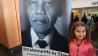 Die kleine Thandi Poppendieck im ehemaligen Gefängnis auf Robben Island vor einem Bild mit Nelson Mandela
