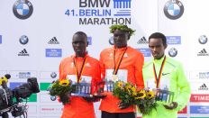 ARCHIV: Der Langstreckenläufer Dennis Kimetto, hier bei der Siegerehrung des 41. Berlin Marathon, zwischen den Zweit- und Drittplatzierten Emmanuel Mutai (li) und Abera Kuma (re.)