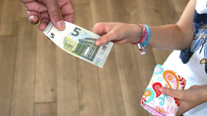 Ein Mädchen bekommt fünf Euro Taschengeld