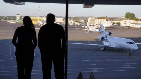 Symboldbild: Im Warteteil des Flughafen Kiew stehen zwei Menschen an der Scheibe und schauen auf das Rollfeld. (Bild: imago/ Bernd Feil/ M.i.S.)