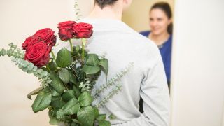 Symbolbild: Ein Mann schenkt seiner Frau Blumen