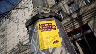 Protestplakat Deutsche Wohnen und Co enteignen an einem Wohnhaus an der Karl-Marx-Allee in Berlin Friedrichshain. (Bild: imago/Ipon)
