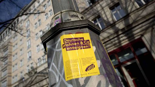 Protestplakat Deutsche Wohnen und Co enteignen an einem Wohnhaus an der Karl-Marx-Allee in Berlin Friedrichshain. (Bild: imago/Ipon)