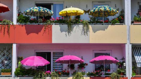 ARCHIV - 20.07.2018, Brandenburg, Frankfurt (Oder): Bunte Sonnenschirme leuchten in der Mittagssonne auf Balkons eines Mehrfamilienhauses. (Bild: dpa/ Patrick Pleul)