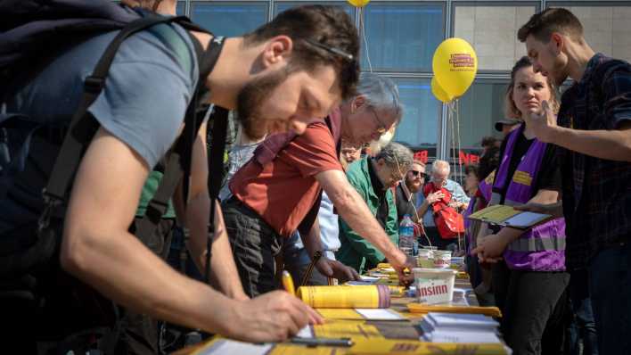 Aktivisten des Volksbegehrens Deutsche Wohnen & Co enteignen sammeln am Auftakt der Mietenwahsinn-Demonstration auf dem Alexanderplatz in Berlin Unterschriften (Bild: imago images / Christian Mang)