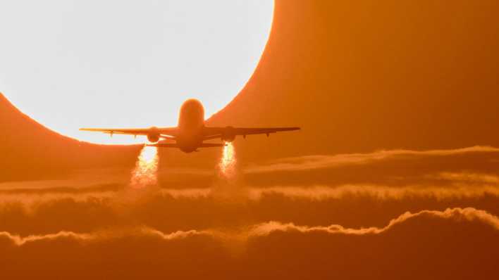 Flugzeug fliegt in den Sonnenuntergang (Quelle: imago/blickwinkel)