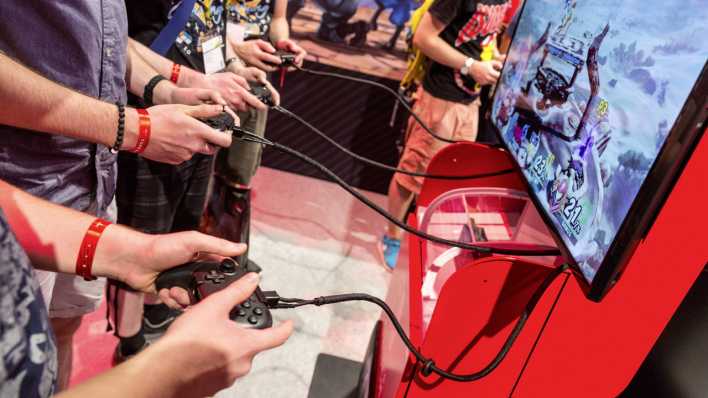 Mehrere Jugendliche spielen an einer Spielekonsole während der Gamescom 2018 in Köln