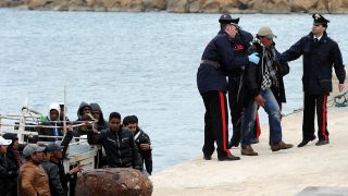 Die italienische Küstenwache auf der Insel Lampedusa hilft tunesischen Flüchtlingen an Land (Bild: dpa)