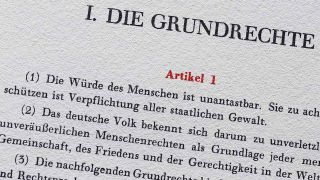 Auszug aus dem Grundgesetz: Artikel 1 (1) "Die Würde des Menschen ist unantastbar" (Bild: imago images/photothek)