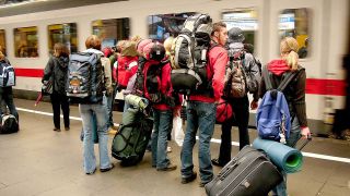 Jugendliche mit Rucksäcken warten am Hauptbahnhof Bonn auf den Zug. (Bild: imago images/JOKER)