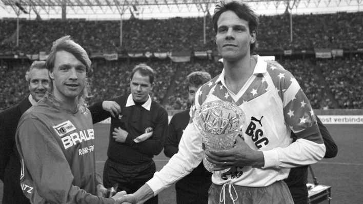 Die beiden Mannschaftskapitäne geben sich vor Beginn des innerstädtischen "Fußball-Gipfels" zwischen Hertha BSC und Union Berlin am 27.01.1990 im Olympiastadion in Berlin die Hand.