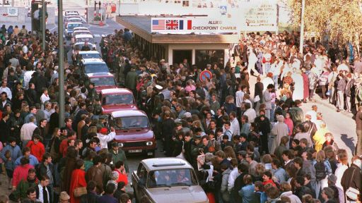 ARCHIV - Berlin: Eine Fahrzeugkolonne schiebt sich am 10.November 1989 in Richtung West-Berlin vorbei am Checkpoint Charlie (Bild: dpa)