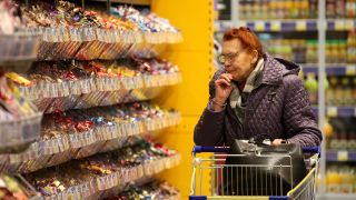 Die Qual der Wahl: Eine Frau steht vor vielen Süßigkeiten.