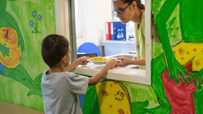 Kind bei der Essensausgabe in der Schule (Bild: imago images/ Christian Ditsch)