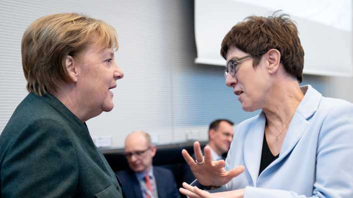 Bundeskanzlerin Angela Merkel (CDU) und Annegret Kramp-Karrenbauer (r, CDU), Bundesministerin der Verteidigung und CDU-Bundesvorsitzende, unterhalten sich zu Beginn der Sitzung der CDU/CSU-Bundestagsfraktion (Bild: dpa)