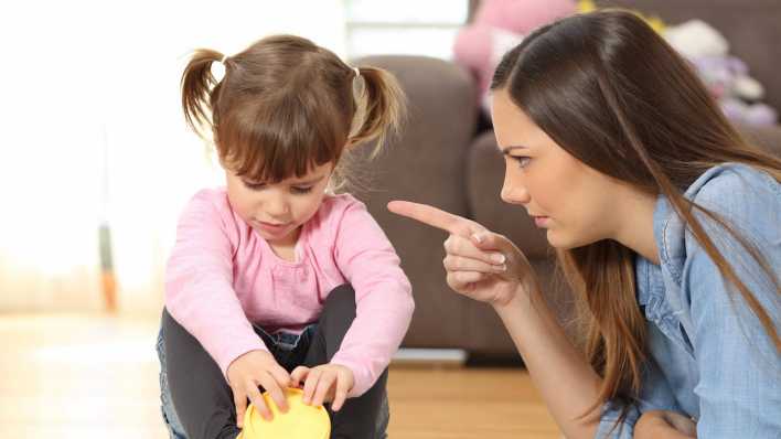 Eine Mutter ermahnt ihre Tochter mit erhobenem Zeigefinger