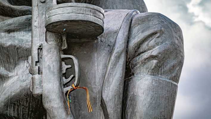 Am Gewehr einer Statue des Sowjetischen Ehrenmals in Berlin hängt ein Bundes Band