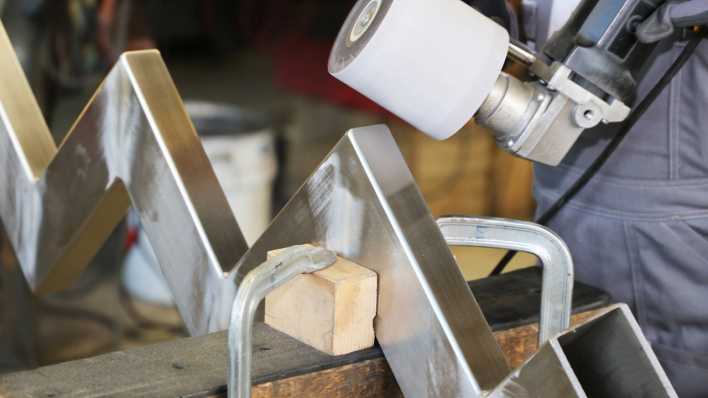 Ein Metallbauarbeiter bearbeitet ein Aluminiumstück (Bild: imago images / U. J. Alexander)