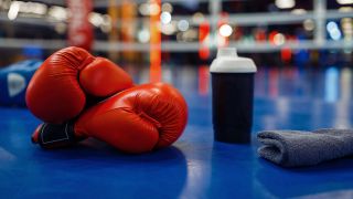 Illustration: Boxhandschuhe in einem Boxring (Bild: imago images/ NomadSoul)