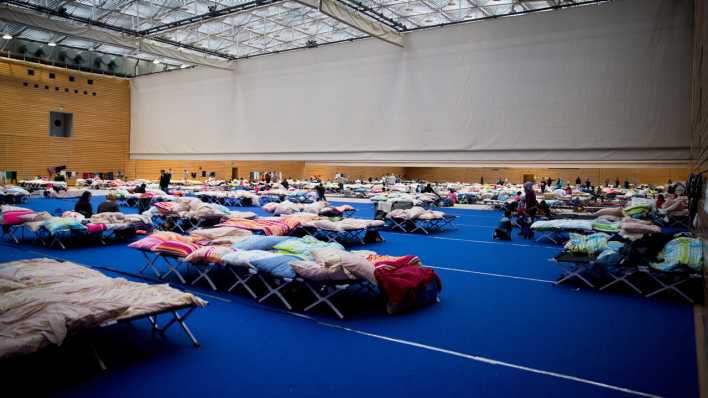 ARCHIV - Zahlreiche Betten stehen am 12.09.2015 in Berlin in einer großen Sporthalle am Olympiapark im Stadtteil Charlottenburg für die Unterbringung von Flüchtlingen.