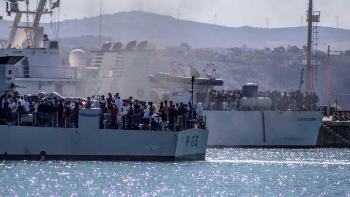 Migranten kommen in Porto Empedocle an Bord von zwei Militärschiffen an, nachdem sie von der Insel Lampedusa dorthin gebracht wurden (Bild: dpa)
