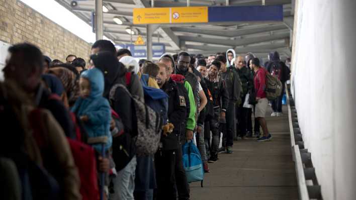 Lange Schlange von Geflüchteten, die im Oktober 2015 mit einem IC aus Salzburg am Bahnhof Flughafen Berlin-Schönefeld angekommen sind. (Bild: imago images / Christian Thiel)