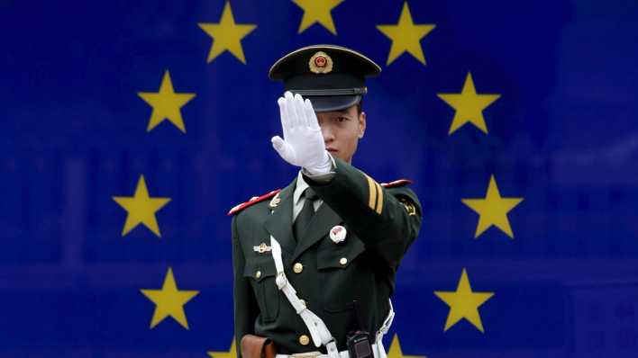 ARCHIV - Ein chinesischer Polizist steht am 02.11.2007 vor der EU-Botschaft in Peking und deutet an, dass er nicht fotografiert werden will.