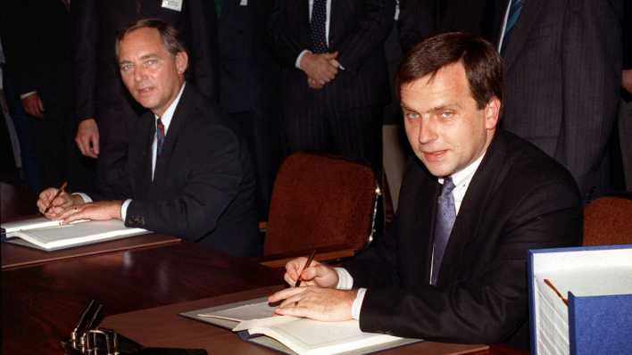 31.08.1990, Berlin: Bundesinnenminister Wolfgang Schäuble (l) und DDR-Staatssekretär Günther Krause bei der Unterzeichnung der Urkunden am 31. August 1990.