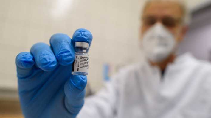 Ein Apotheker im Impfzentrums zeigt ein leeres Fläschchen in dem sich der Impfstoff von Pfizer-Biontech befunden hatte und der bereits verimpft wurde.