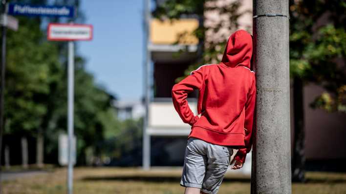 Ein Kind steht vor einem Plattenbau in Leipzig-Gruenau.