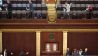 Abgeordnete verlassen das Parlament, während Polizisten mit gezogenen Waffen einen Eingang sichern (Bild: imago images/UPI Photo)