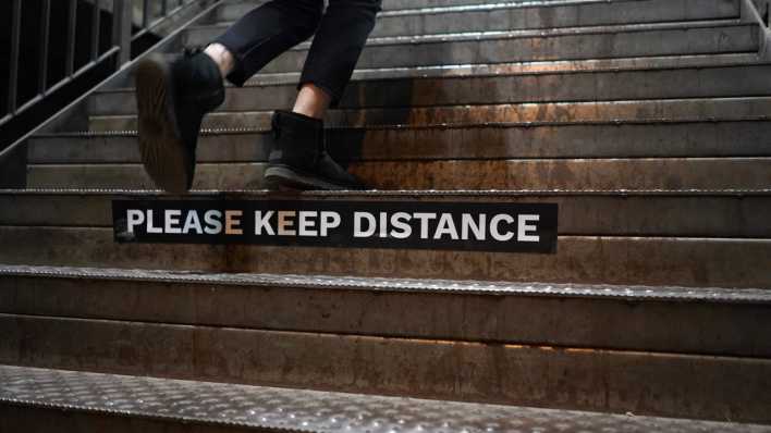 Ein Schild mit der Aufschrift «Please keep distance» (bitte halte Abstand) ist auf einer Treppe in Berlin zu sehen.